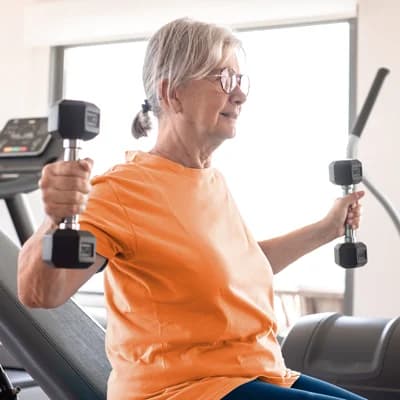 Senhora sênior praticando exercício físico com halteres